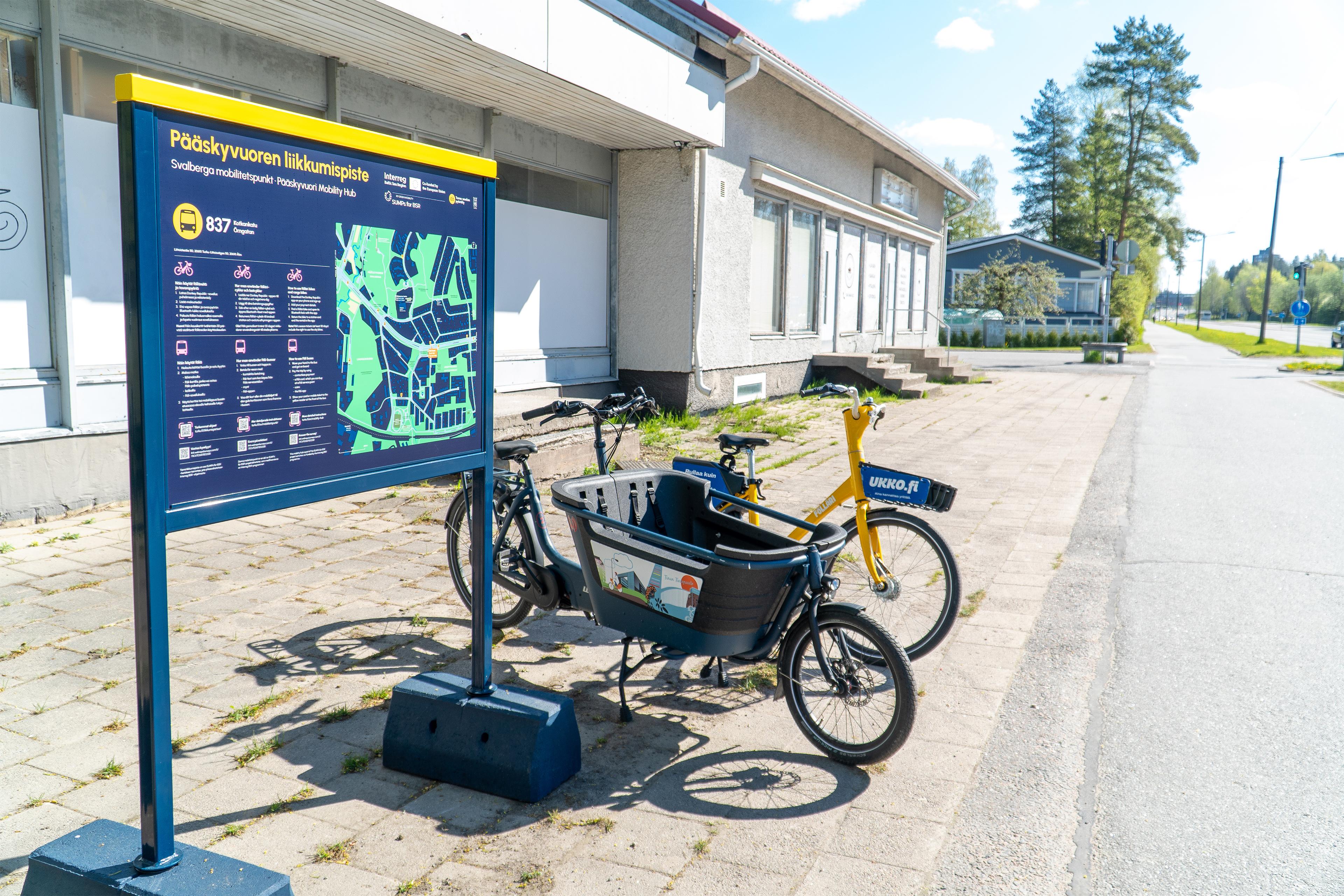 Liikkumispisteellä on opaskyltti, fölläri ja tavarapyörä